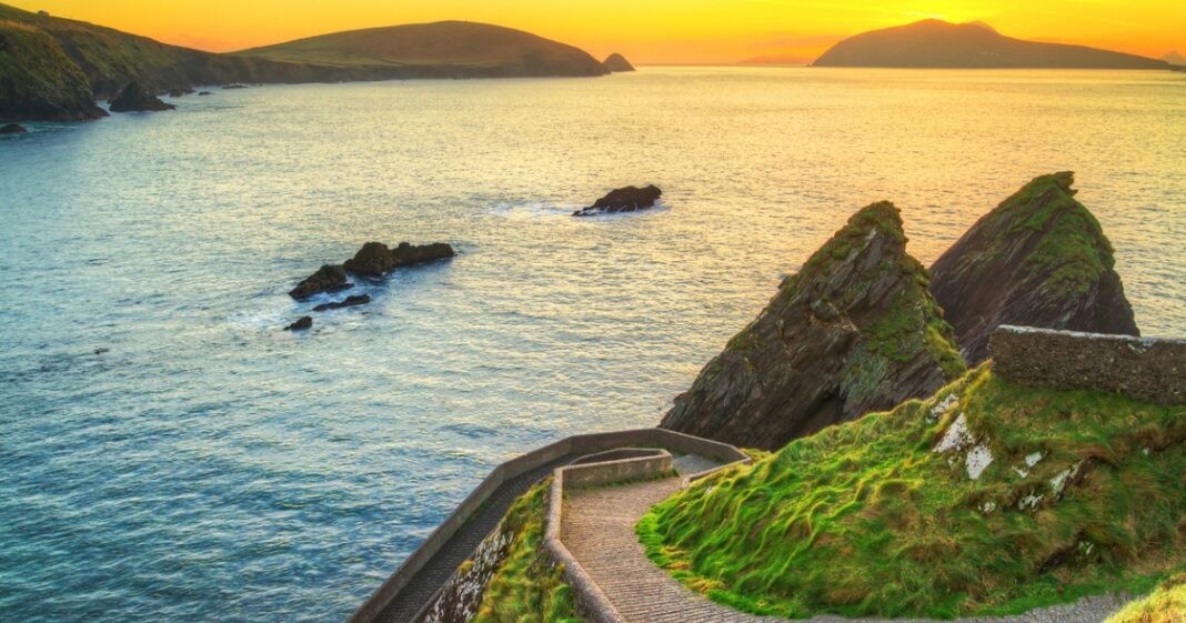 Kerry: El epicentro de la épica irlandesa No es una coincidencia que en Irlanda se refieran a Kerry con el título de «El Reino»; es el reconocimiento a una tierra que ha exportado genialidad en todas sus formas. Desde la resistencia física de Tom Crean —el explorador antártico que cambió los icebergs por el mostrador de un pub en su natal Annascaul— hasta la agudeza política de Daniel O’Connell, el condado ha moldeado personalidades determinantes. Incluso el cine contemporáneo encuentra aquí sus raíces, con un Michael Fassbender que reclama a Kerry como el escenario de su infancia. El fervor cultural se manifiesta cada invierno en Dingle, donde el festival Other Voices atrae a la aristocracia del pop y el rock internacional a un entorno íntimo y casi sagrado. Por otro lado, la localidad de Listowel sigue siendo el bastión de la palabra escrita, honrando la máxima de John B. Keane sobre la facilidad de la creación literaria en estas latitudes. Esta excelencia se traslada también al césped, donde la supremacía de sus equipos en el fútbol gaélico es ya un hecho estadístico indiscutible. En Kerry, la historia no se escribe; se vive con la intensidad de los campeones.